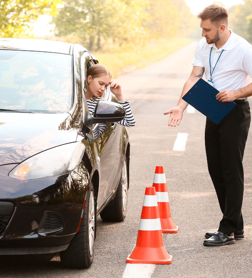 Driving Instructor Guiding A Student Driver During A Lesson With Traffic Cones