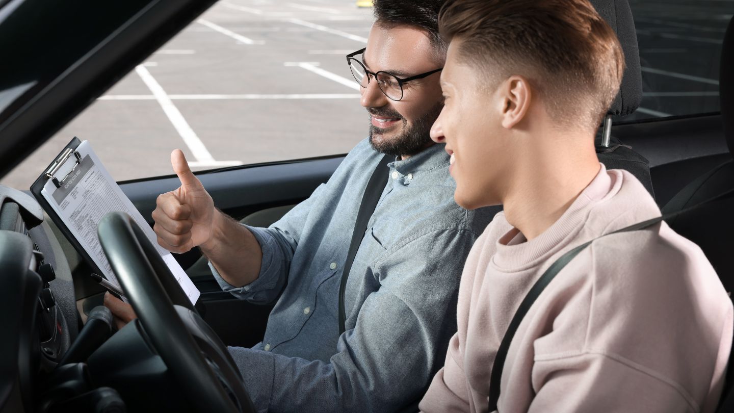 Driving Instructor Giving Thumbs Up To Student 