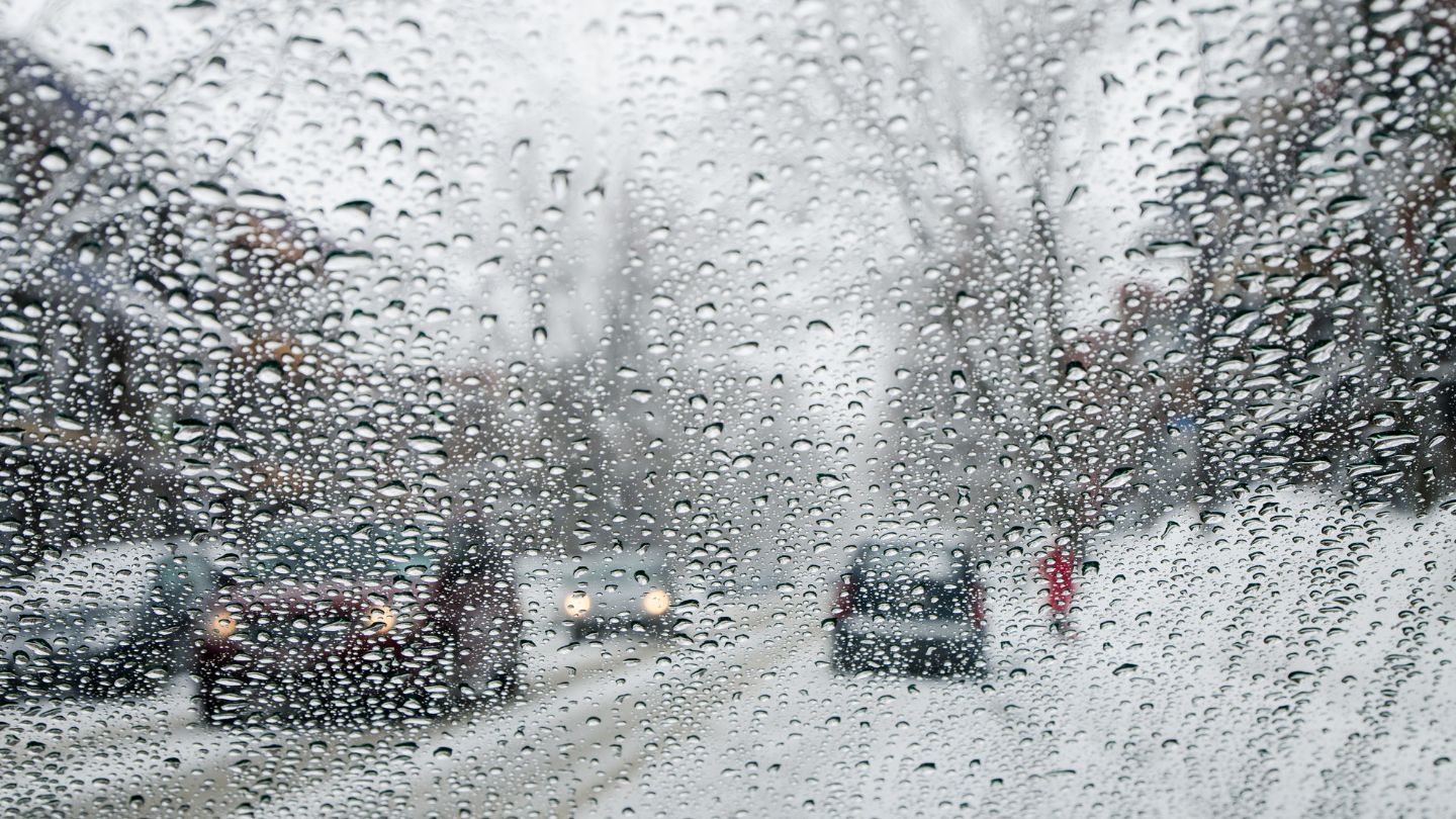 Snow Covered Windshield With Blurry Road View 